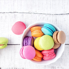 Top view flat lay Vibrant colorfull macarons on white wooden table. Text space