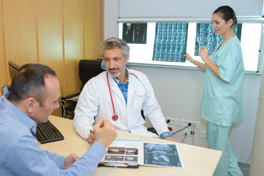 Medical workers discussing xrays with patient
