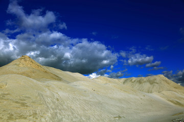 Kopalnia odkrywkowa, góra piasku na tle pochmurnego nieba.