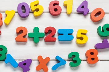 Fototapeta premium Multicolored numbers on a wooden background. View from above. For your design.