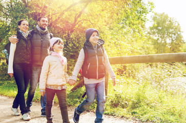 happy family with backpacks hiking in woods