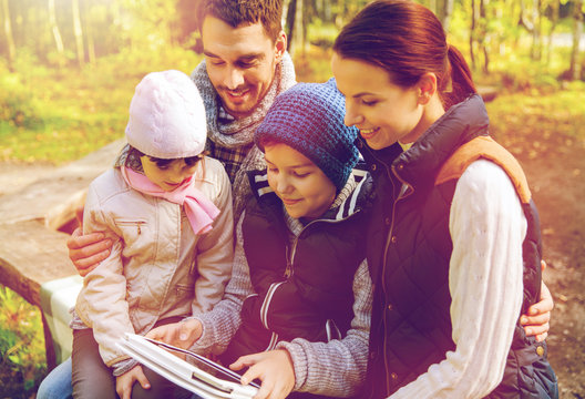 happy family with tablet pc and backpacks at camp