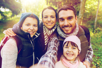 family with backpacks taking selfie and hiking