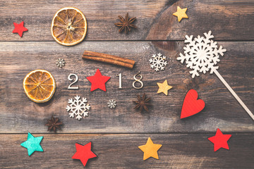 New Year Christmas theme with decorative 2018 figures, anise stars, cinnamon sticks, decorative stars and snowflake on wooden board.