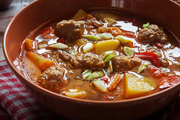 Lentil soup with meatballs and pepper closeup