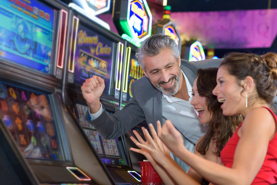 people gambling in a casino playing slot machine