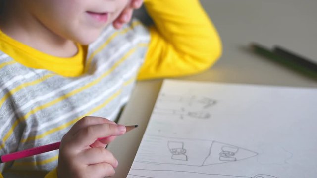 Little cute little girl draws a happy looking at the camera. 4K.