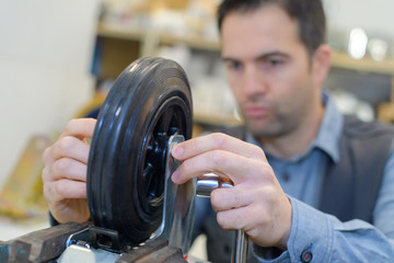 yougn man setting trolley wheel in factory workshop