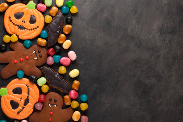 Halloween pumpkin, bat and gingerbread man-vampire cookies and colorful candy overhead shot with copy space