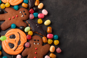 Fototapeta na wymiar Halloween pumpkin, bat and gingerbread man-vampire cookies and colorful candy overhead shot with copy space