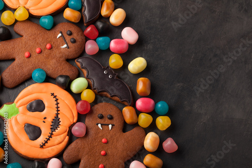 Halloween pumpkin, bat and gingerbread man-vampire cookies and colorful candy overhead shot with copy space