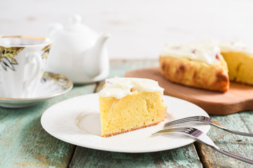 Old fashioned English cake with whipped cream served with tea on robin egg blue wooden table