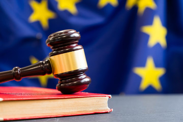 Judges wooden gavel with EU flag in the background. Symbol for jurisdiction. Wooden gavel on...