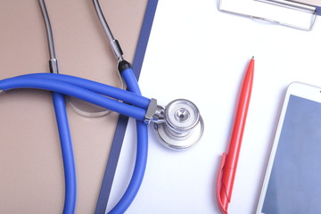 Medical stethoscope with cardiogram lying on desk in hospital