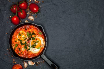 Photo sur Plexiglas Oeufs sur le plat Breakfast. Shakshuka with bread in pan on a black rustic background. Fried eggs with tomatoes. Top view. Space for text. Middle eastern style breakfast or lunch