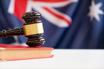 Gavel and legal book on wooden table, collage with flag of australia