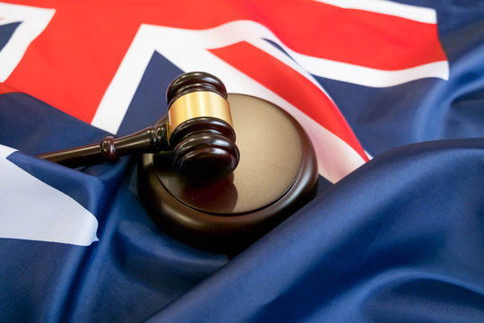 Gavel and legal book on wooden table, collage with flag of australia