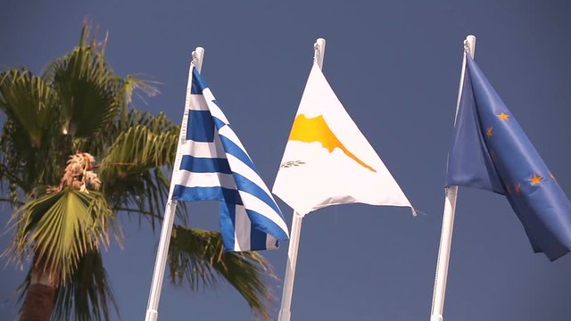 Flags of the European Union, Greece, Cyprus, the city of Aya Napa, Greece, Flags on the flagpole, the wind waving the flag, Flags on flagpole, wind waving flag, against blue sky background