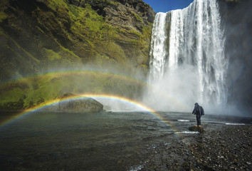 Tourist standing near Skogafoss waterfall, Iceland