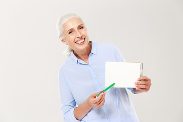 Smiling mature woman showing notebook with copy space for text isolated