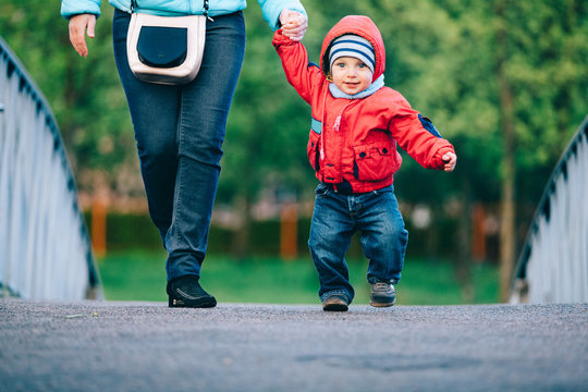 Little Boy With Mother Walking Outdoors Holding Mother's Hand