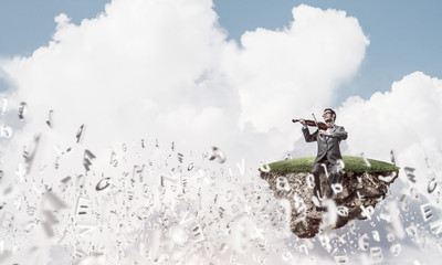 Handsome violinist play his melody and letters fly around in air