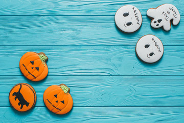 Fresh halloween gingerbread cookies on blue wooden table.