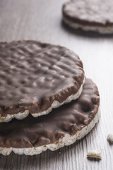 Rice biscuits and crackers in chocolate on the  warm table