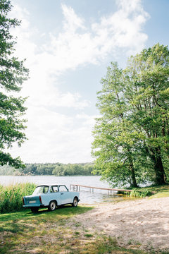 Blue GDR Vintage Car Parked Near Lake on Sunny Day