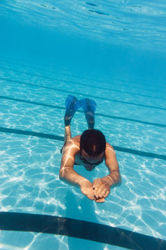 Young Caucasian man diving in swimming pool