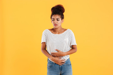 Young woman holding her stomach isolated