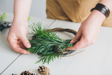 Florist decorator making Christmas wreath