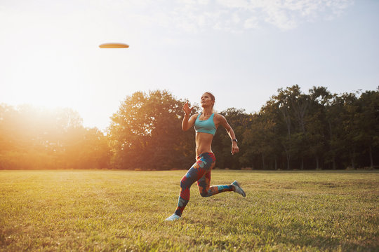 Young athletic girl playing with flying disc, ultimate