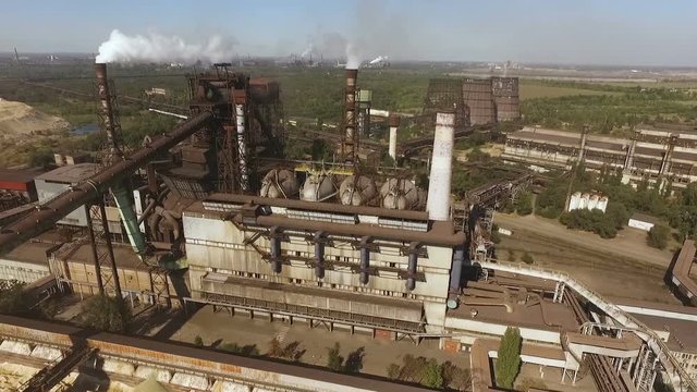 aerial video shooting of the plant, the camera moves in front of the blast furnace from the pipes goes thick white smoke