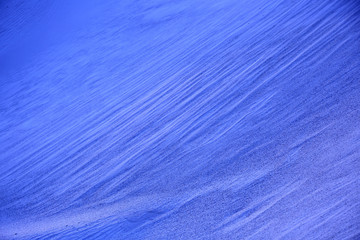 Naturalnie pofalowany piasek na wydmie morskiej nocą.