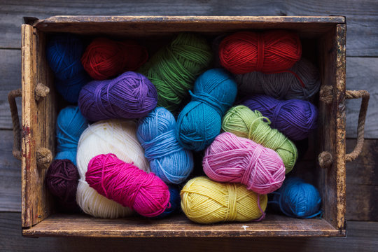 Colourful balls of wool in a wood box