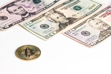 New banknotes of US dollars and a gold coin of crypto currency on a white background.