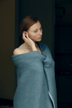 portrait of young woman covered in blue blanket
