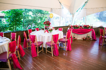wedding hall with red coloured chairs and tables
