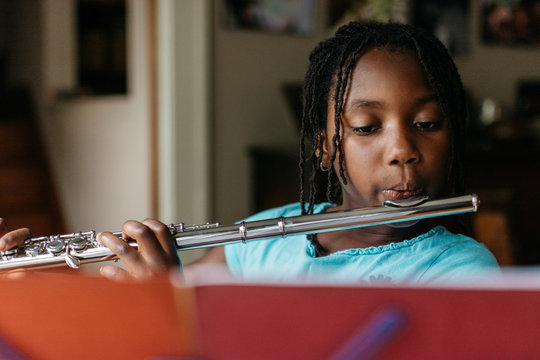 Young African American girl practicing flute