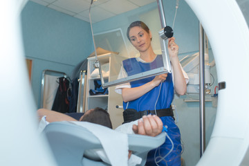 radiologist positioning glass screen beside patient