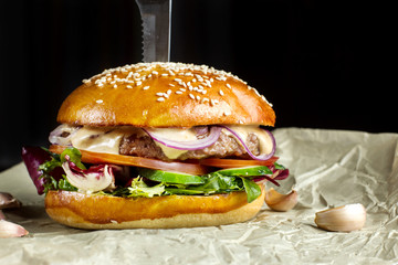 Hamburger with garlic is on kraft paper.
