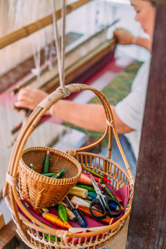 Wicker basket with sewing tools hanging on the wall