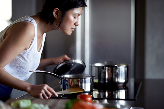 Asian woman cooking in kitchen