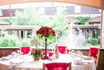 wedding table set for fine dining or another catered event in red colors