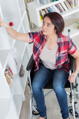 woman sitting on wheelchair at home