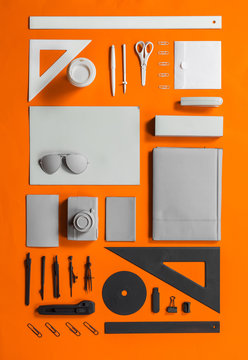 Well organised white grey and black office stuff on orange background