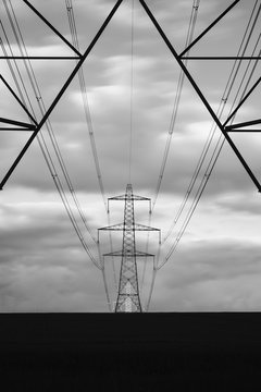 Distant electricty pylon lit by light at sunset. Norfolk, UK.