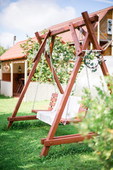 Fototapeta na wymiar vintage wooden swing in the garden near house