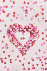 Sugar Sprinkles Candies in Heart Shape Scattered on White Stone Background. Valentine Romantic Birthday Charity Mother's Day. Greeting Card Poster Template.